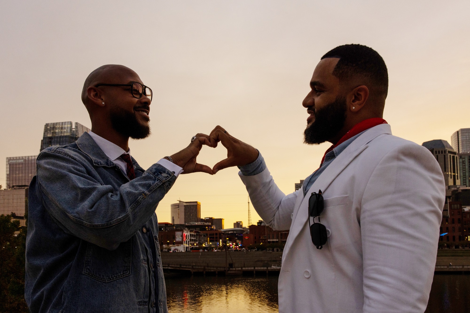 Aaron and Deonte making a heart with their hands against the Nashville skyline at sunset