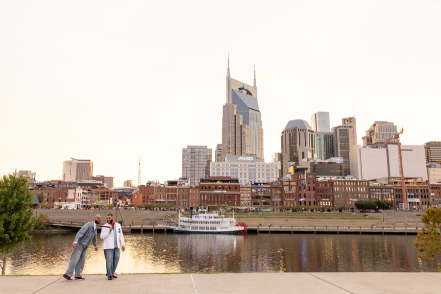 Standing on the riverfront with the Nashville skyline behind them