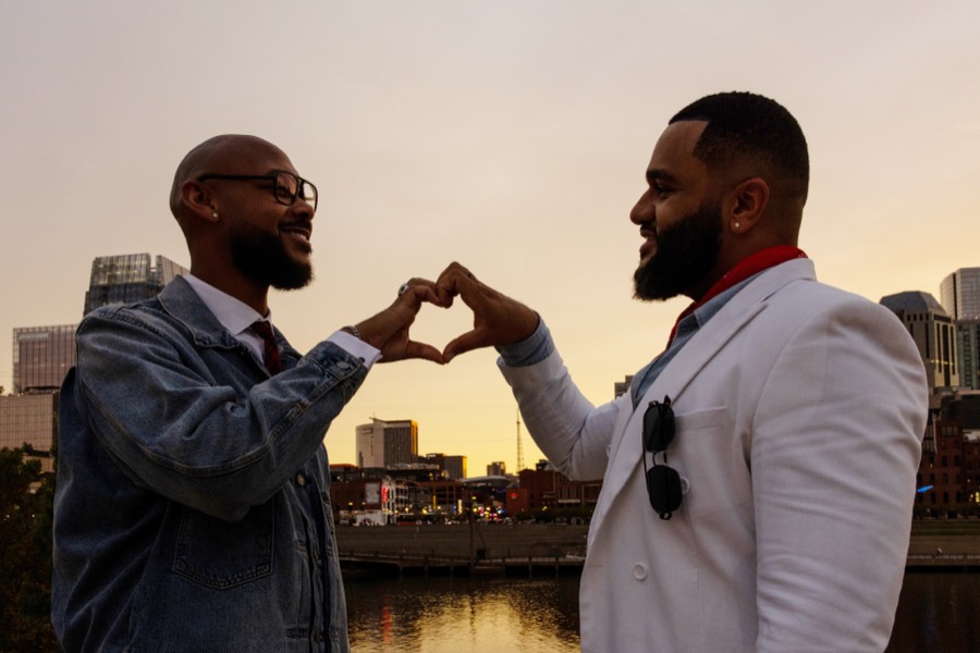 Heart hands at sunset against the skyline