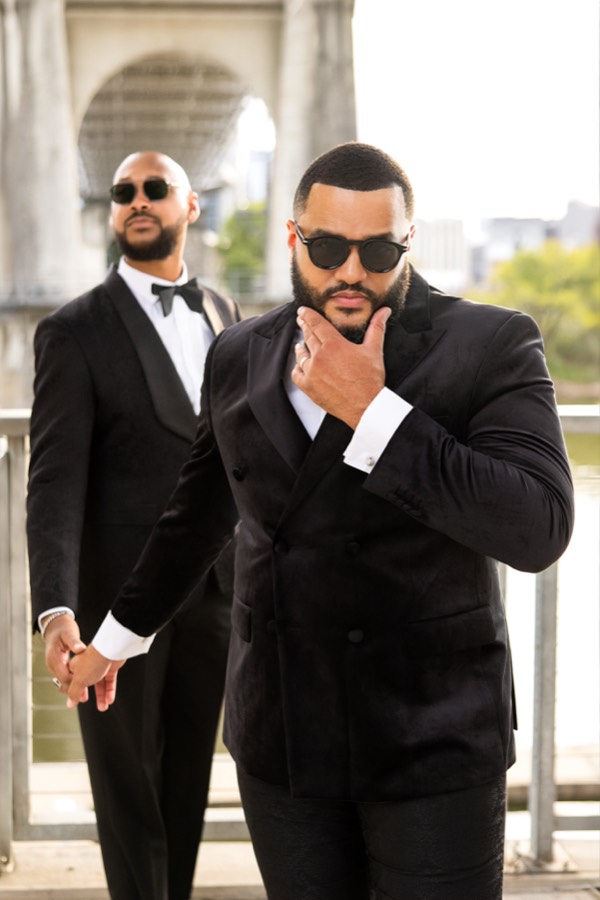 In black tuxedos and sunglasses on the bridge